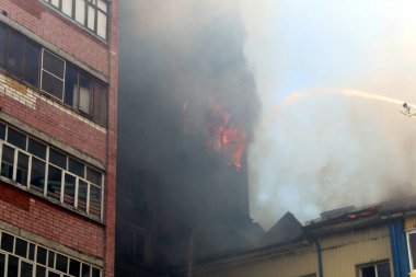 Sıcak, güneşli bir günde, yazın yanan bir binanın bulanık fotoğrafı.