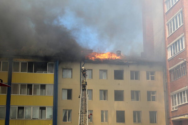 Blurred photo, two firefighters rescuers climb the stairs to the fire