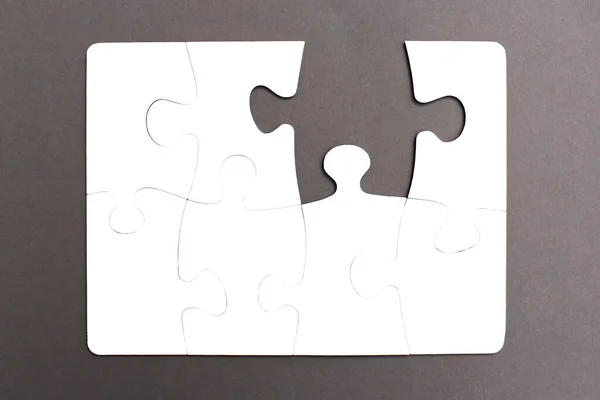 Puzzle Blanc Assemblé Sur Fond Gris Avec Une Pièce Ébréchée — Photo