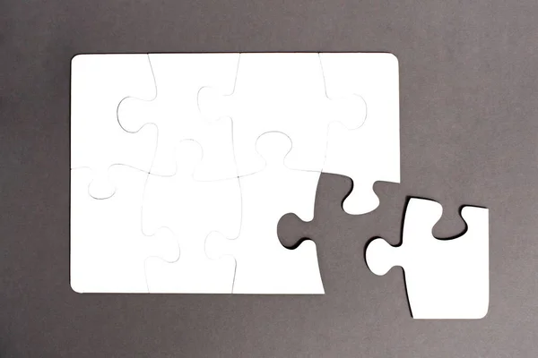 Puzzle Blanc Assemblé Sur Fond Gris Avec Une Pièce Ébréchée — Photo