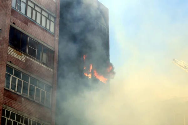 Blurred photo of a high-rise building on fire in summer on a hot sunny day