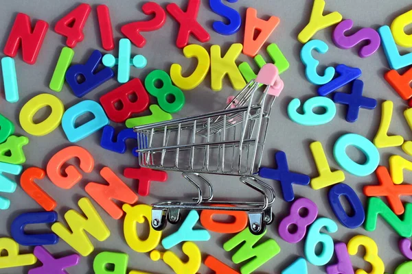 Miniature Shopping Cart Lies Surface Bright Plastic Letters — Stock Photo, Image