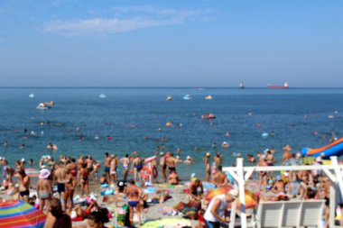 Bulanık fotoğraf. Deniz kenarındaki yaz plajında bir sürü insan sahilde dinleniyor..