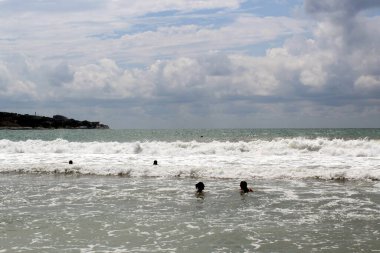Luli denizde fırtınada yıkanır. Güneşli, rüzgarlı bir gün.