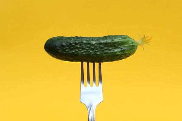 放在黄色背景的叉子上的新鲜黄瓜 — 图库照片