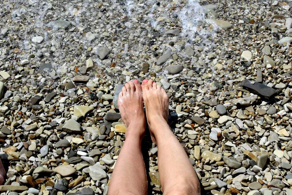 Frauenfüße Liegen Einem Kieselstrand Der Vom Meerwasser Gewaschen Wird — Stockfoto