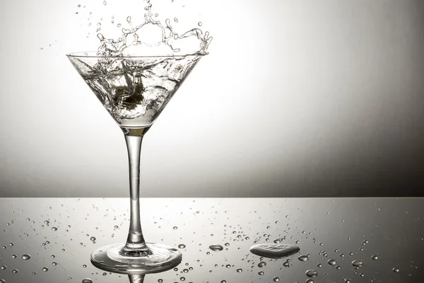 Olive splashing on martini — Stock Photo, Image