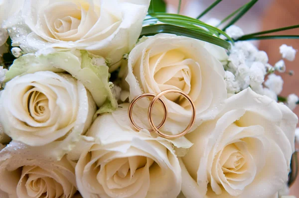 Svatební prsteny na kytici růží — Stock fotografie