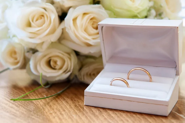 Anillos de boda con un ramo de rosas — Foto de Stock