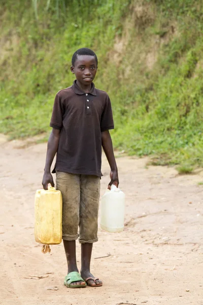 Africký kluk vozí voda — Stock fotografie