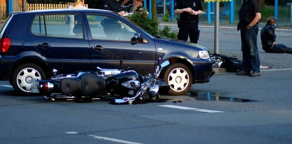 Motosiklet ve araba kazası geçiren bir polis.