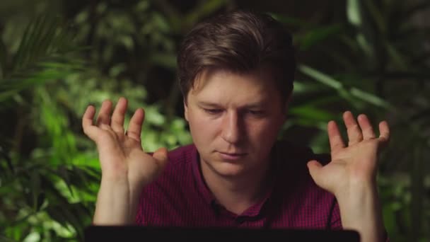 Mann som gjør fysiske øvelser for hender mens han sitter ved datamaskinen – stockvideo