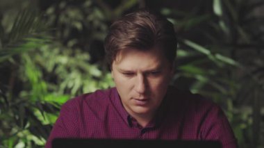 Kızgın adam bilgisayarın başında çalışırken bağırıyor.