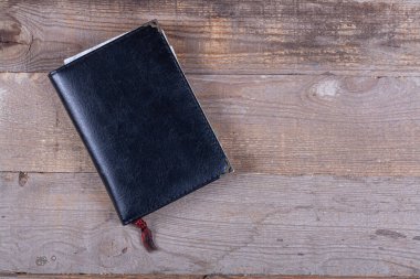 Ahşap arka planda siyah defter, yakın plan.,