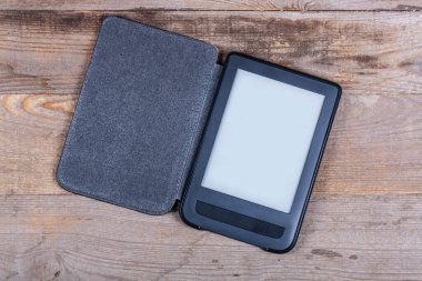 Ahşap arka planda siyah bir e-kitap okuyucusu