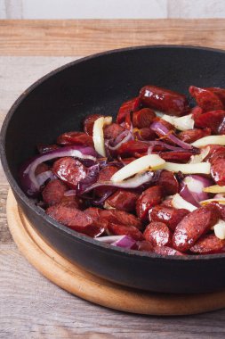 Demir tavada sebzeli kızarmış sosis. Biber ve soğanlı et yemeği pişiriyorum.