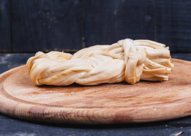 Ahşap mutfak tahtasında füme peynir yakın.