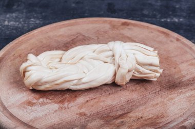 Ahşap mutfak tahtasında füme peynir yakın.