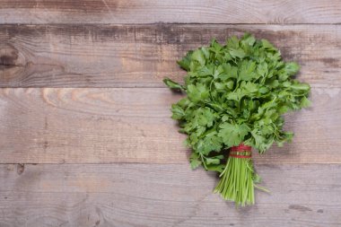 Ahşap arka planda küçük bir maydanoz buketi.