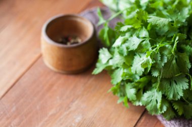 Taze yeşillikler, ahşap arka planda kişniş, yazı için yer, yakın plan, üst görünüm.