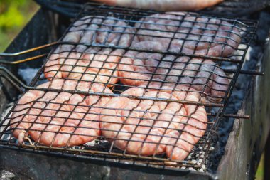 Izgarada kızartılmış yuvarlak sosisler..