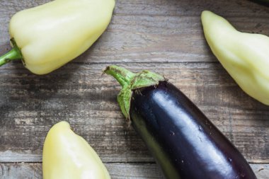 Ahşap arka planda mor patlıcan ve dolma biber. Yakın plan.