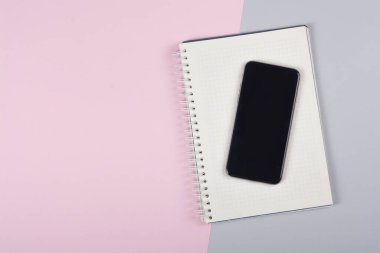 Ofis aksesuarlarıyla fotokopi alanı olan sağlam bir arka planda akıllı telefon. Modern ve minimal stil üst görünümü kapat