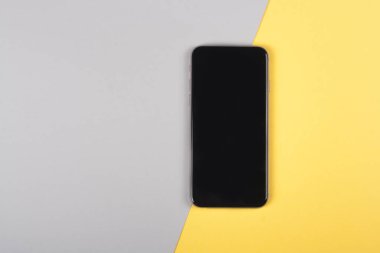 Kopyalama alanı olan renkli arkaplanda akıllı telefon. Modern ve minimal stil üst görünümü kapat