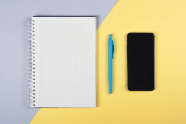 Ofis aksesuarlarıyla fotokopi alanı olan sağlam bir arka planda akıllı telefon. Modern ve minimal stil üst görünümü kapat