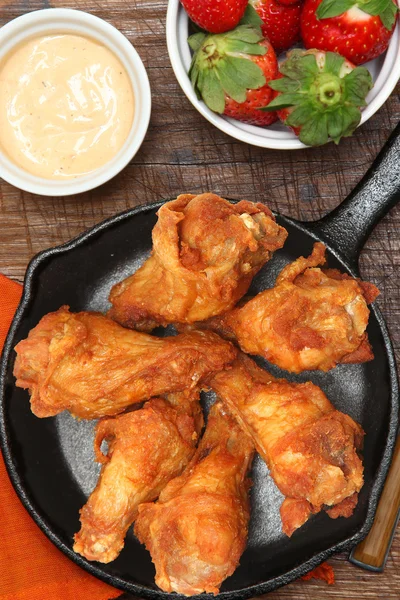 Asas de frango em frigideira com morangos e molho — Fotografia de Stock