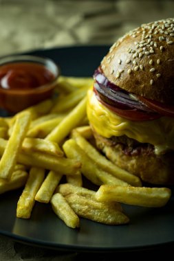 Patates kızartmalı çizburger ve kağıt üzerinde domates sosu