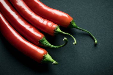 Siyah zemin üzerinde kırmızı baharatlı biberlerin fotokopi alanı olan görüntüsünü kapat