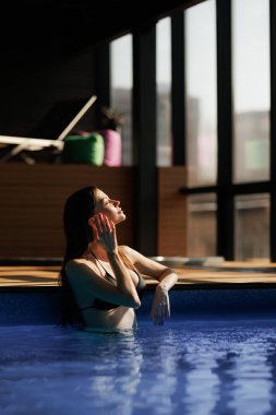 Relaxed woman standing at poolside of spa complex