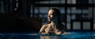 Web banner of woman swimming in pool in sunlight