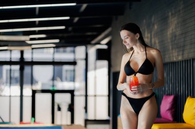 Mayolu kadın spa kompleksinde kokteyl tutuyor.