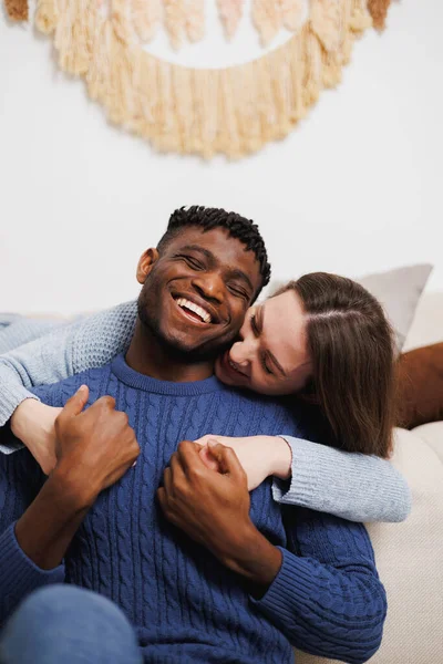 Mutlu kadın, evde neşeli Afrikalı Amerikalı erkek arkadaşının elini tutuyor.