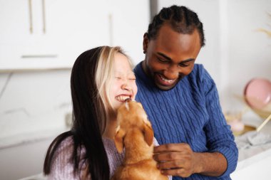 Kazaklı mutlu genç çift evde chihuahua köpeğiyle eğleniyor.