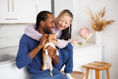 Evde Chihuahua köpeğiyle oynayan ırklar arası pozitif bir çift.