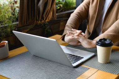 Kesilmiş iş adamı görüşü kahvenin yanındaki bilgisayarda çalışmaya başlar ve kafenin terasına çıkar.