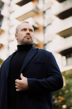 Şehirde kulaklık takan kendine güvenen bir adamın portresi.