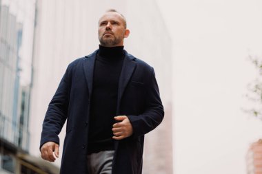 Sonbaharda şehir caddesinde yürüyen kendine güvenen işadamı