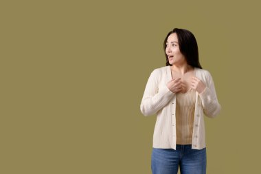 Şaşırmış esmer Asyalı kadın yeşil üzerine inzivaya çekilmiş.