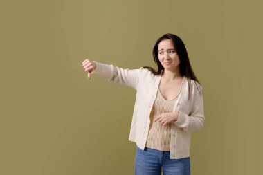 Hoşnut olmayan Asyalı kadın yeşilde izole edilmiş gibi görünüyor.