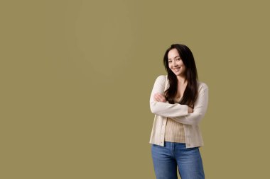 Güzel ve neşeli Asyalı kadın yeşil kameraya bakıyor.