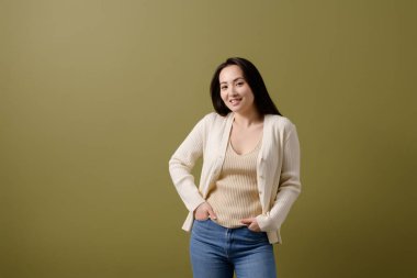 Kot pantolon ve hırka giymiş gülümseyen Asyalı kadın yeşil, vücut pozitifliği