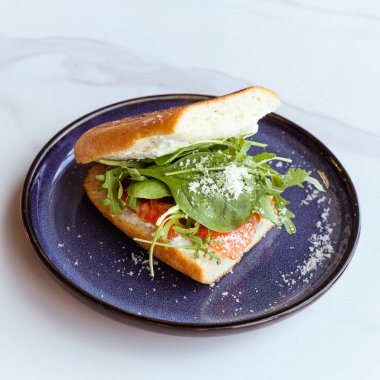 Chiabatta 'lı lezzetli sandviç, kafede taze salata ve somon balığı.