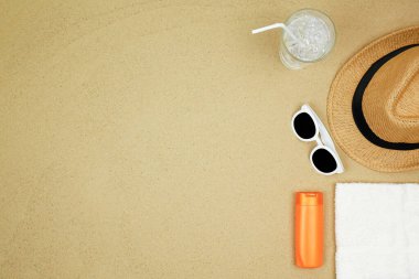 En üstte bir şapka, güneş gözlüğü, ayakkabı ve su kumsalda içilir..