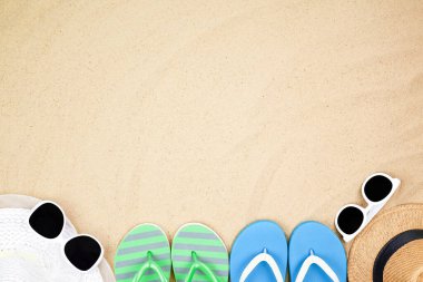 Top view seyahat plaj arka plan kavramı güneş gözlüğü, ayakkabı ve kumdaki plaj şapkası.