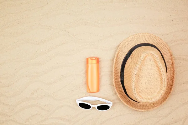 Top view seyahat plaj arka planı konsepti güneş gözlüğü ve kumdaki plaj şapkası..