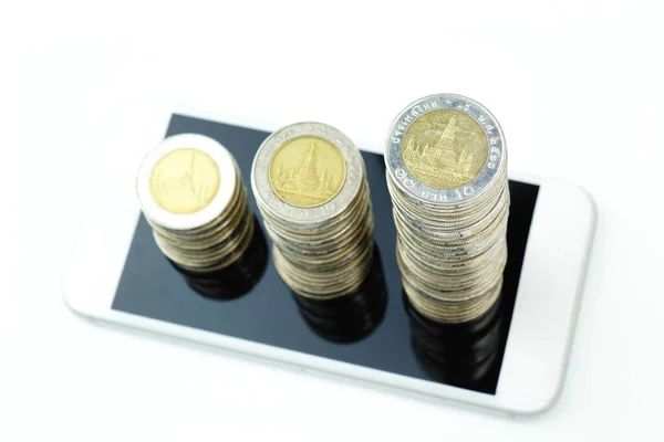 stock image A coin stack growth increase on smart phone. Business concept.